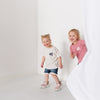 Two toddlers smiling and playing, wearing matching bff club t-shirt.