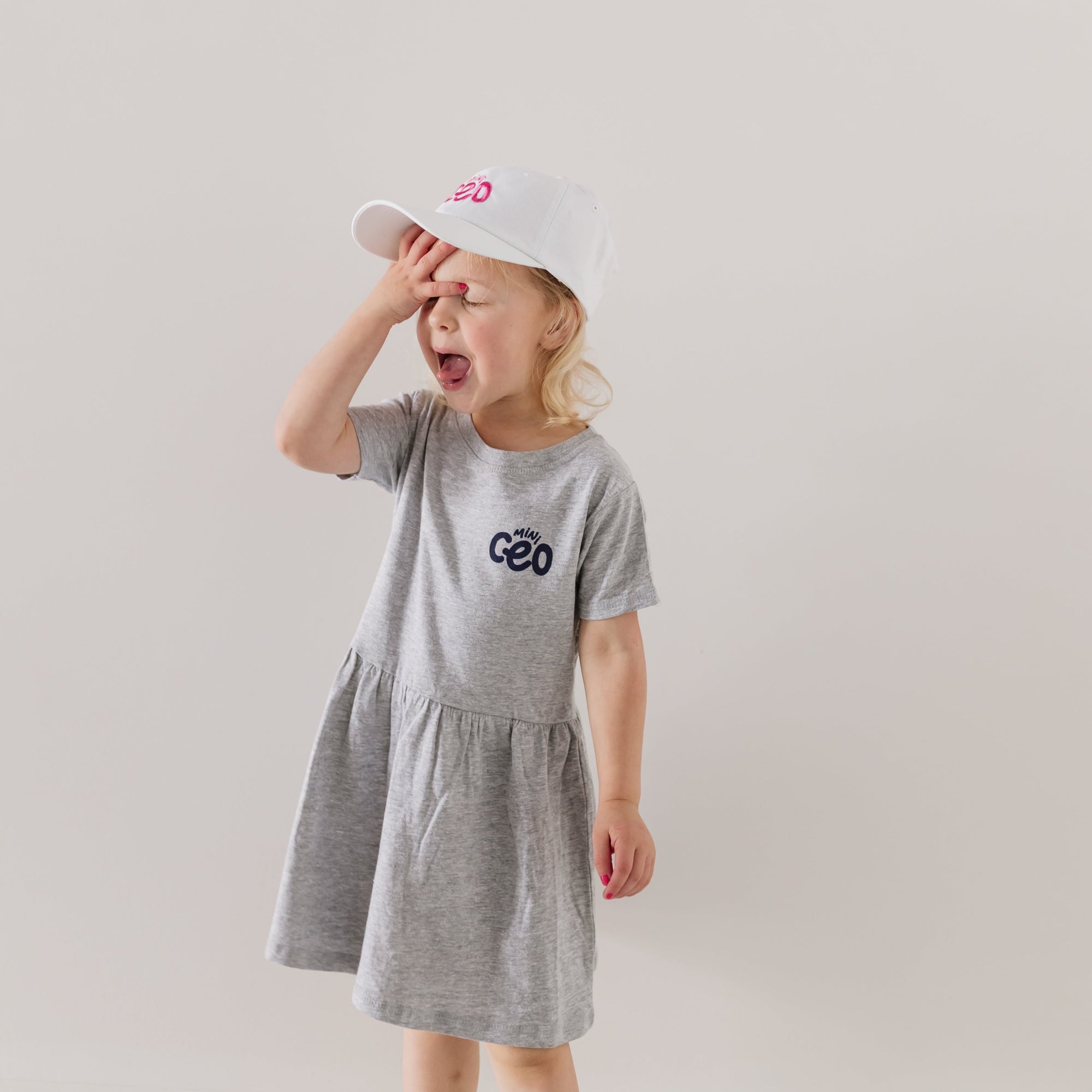 toddler girl wearing mini ceo dress and mini ceo white hat with pink embroidery