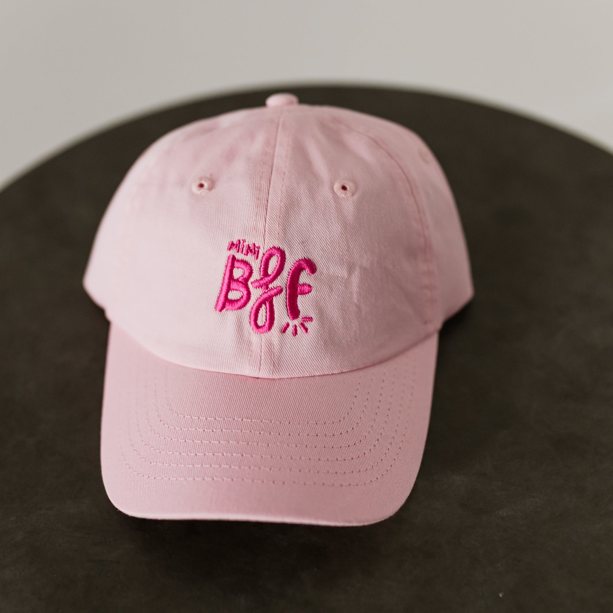light pink baseball cap with dark pink embroidery saying mini bff