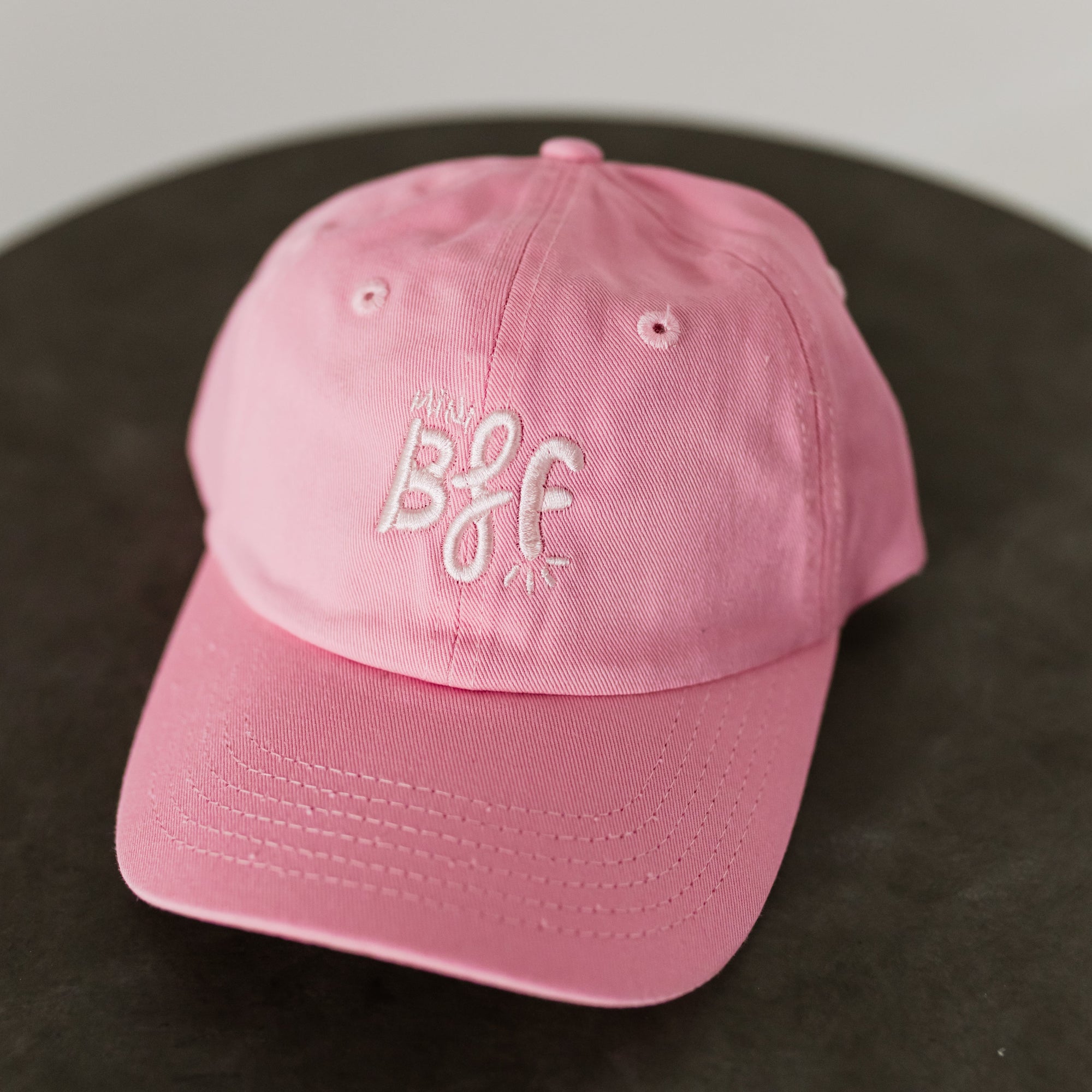 pink baseball cap with light pink embroidery saying mini bff