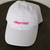 white baseball cap embroidered with pink thread "Solopreneur" on a table