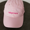 pink baseball cap embroidered with "Solopreneur" on a table