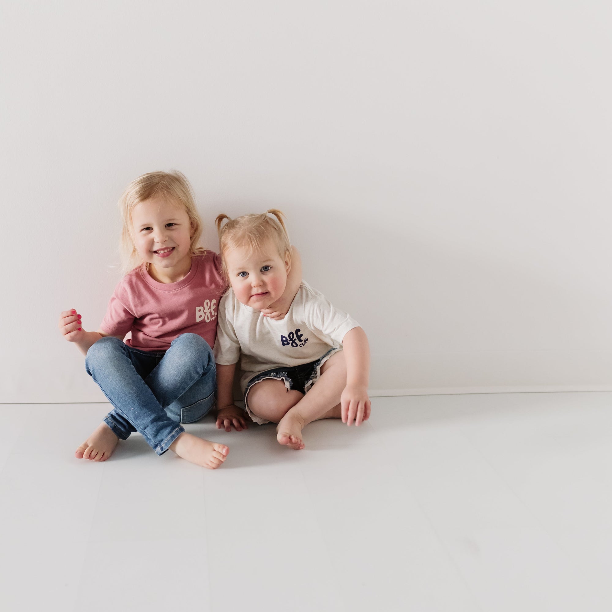 two toddlers sitting next to each other wearing matching t-shirts that say bff club