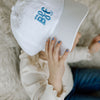 toddler girl wearing white baseball cap with light blue embroidery saying mini bff